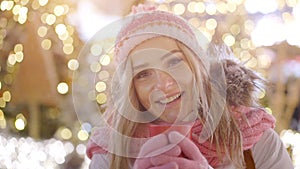 Beautiful smiling woman in warm clothing with red cup of hot tea or coffee