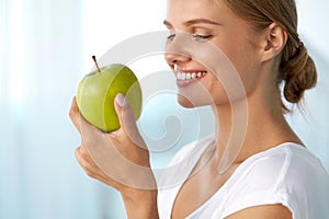 Beautiful Smiling Woman With White Teeth Eating Green Apple