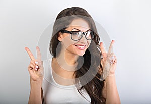 Beautiful smiling womanin eyeglasses showing two fingers victory