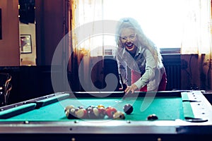 Beautiful smiling women playing billiards