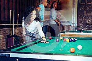 Beautiful smiling women playing billiards