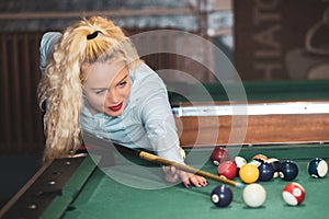 Beautiful smiling women playing billiards at a bar