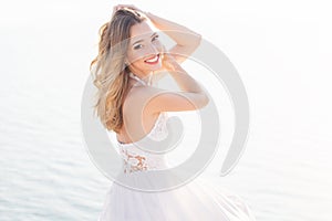 Beautiful smiling young bride girl over the sea