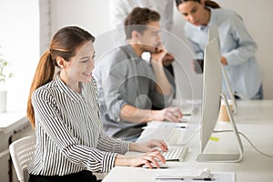 Beautiful smiling young businesswoman working on desktop compute