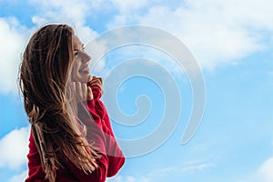 Beautiful smiling young girl, against a sky