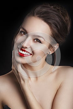 Beautiful smiling young model with red lips and red manicure