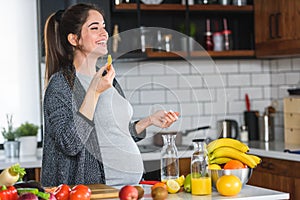 Pregnant woman preparing healthy food with lots of fruit and vegetables at home
