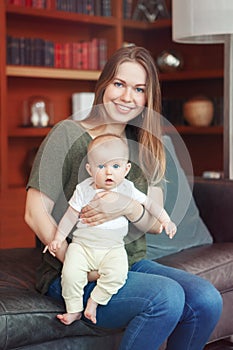 Beautiful smiling young white Caucasian woman mother holding cute adorable baby boy girl