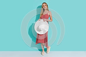 Beautiful Smiling Young Woman In Long Red Summer Dress Is Standing With White Straw Hat