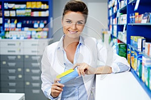 Beautiful smiling young woman pharmacist doing his work in pharmacy.