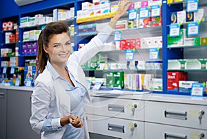 Beautiful smiling young woman pharmacist doing his work in pharmacy.