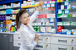 Beautiful smiling young woman pharmacist doing his work in pharmacy.