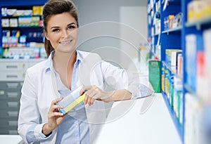 Beautiful smiling young woman pharmacist doing his work in pharmacy.