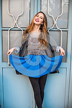 Beautiful smiling young woman posing wearing casual clothes and blue skirt