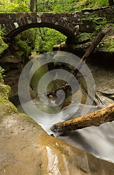 Beautiful smooth flowing stream under a stone bridge at Hocking Hills State Park, Ohio.