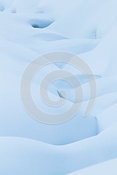 Beautiful smooth lines texture of snowdrifts play of light and shadow of a winter landscape on the background