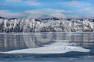 Beautiful snow formations on frozen lake surface in winter