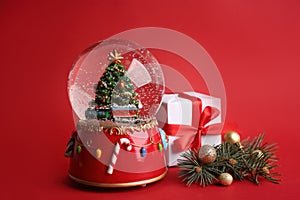 Beautiful snow globe and Christmas decor on red background