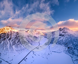 Beautiful snowy mountains in winter at sunset. Aerial view