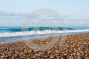 Beautiful soft sea wave on the beach with small pebbles and sand
