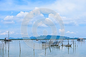 Beautiful Songkhla lake in southern of Thailand with a few of hut as foreground and mountains, blue sky, white cloud as background