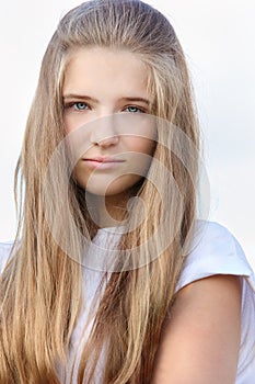 Beautiful sorrowful girl with long hair looks photo