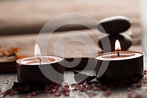 Beautiful Spa composition with aroma candles and empty vintage open book on wooden background.