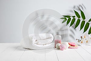 Beautiful spa composition on massage table in wellness center, copyspace. Leaves` shadows on the wall