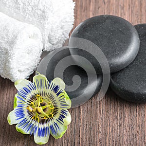 Beautiful spa still life of passiflora flower, black zen stones