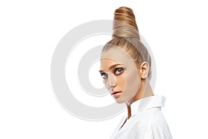 Beautiful spectacular blonde lady with an unusual high hairdo with big blue eyes on a white background