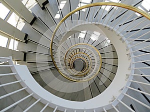 Beautiful spiral staircase with golden handrails design circular shapes photo