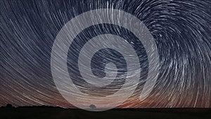 Beautiful Spiral Star Trails over filed with lonely tree.