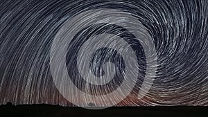 Beautiful Spiral Star Trails over filed with lonely tree. Beautiful night sky.