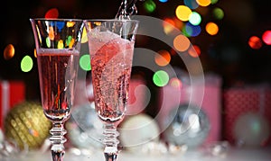 Beautiful splash of pink champagne glasses and Christmas lights