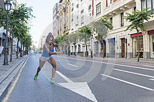 Beautiful sport african woman running in the street, health lifestyle c