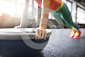 Beautiful sport woman exercising on balance ball in gym, performing pushups. Routine workout for woman& x27;s physical