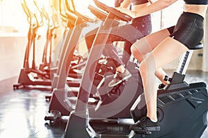 Beautiful sport woman working out on exercise bike at sport health club