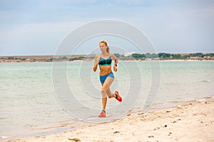 Beautiful sportive woman running along beautiful sandy beach, healthy lifestyle, enjoying active summer vacation near