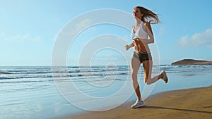 Beautiful sportive woman running along beautiful sandy beach, healthy lifestyle, enjoying active summer vacation near