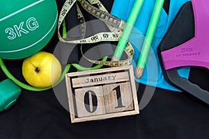 beautiful sports equipment with a wooden clock on January 1 on a spacious black background.