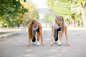 Beautiful, sports girls exercising on a park background. Fitness lifestyle concept. Copy space.