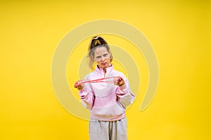 Beautiful sportsgirl with skipping rope isolated on yellow studio