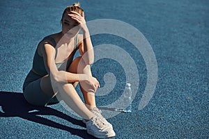 beautiful sportswoman in activewear sitting next