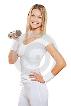 Beautiful sporty female wearing sports clothes holding dumbbell