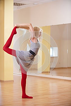 Beautiful sporty fit yogi woman practices yoga asana Natarajasana - Lord Of The Dance pose in the fitness room