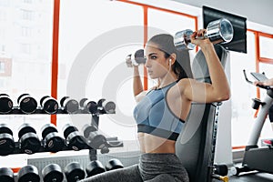 Beautiful sporty woman doing power fitness exercise at sport gym.