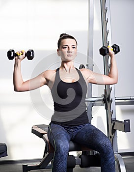 Beautiful sporty woman doing power fitness exercise at sport gym