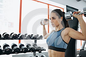 Beautiful sporty woman doing power fitness exercise at sport gym. photo