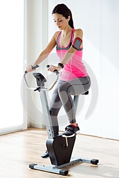 Beautiful sporty young woman doing exercise in gym.