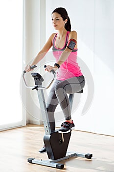 Beautiful sporty young woman doing exercise in gym.
